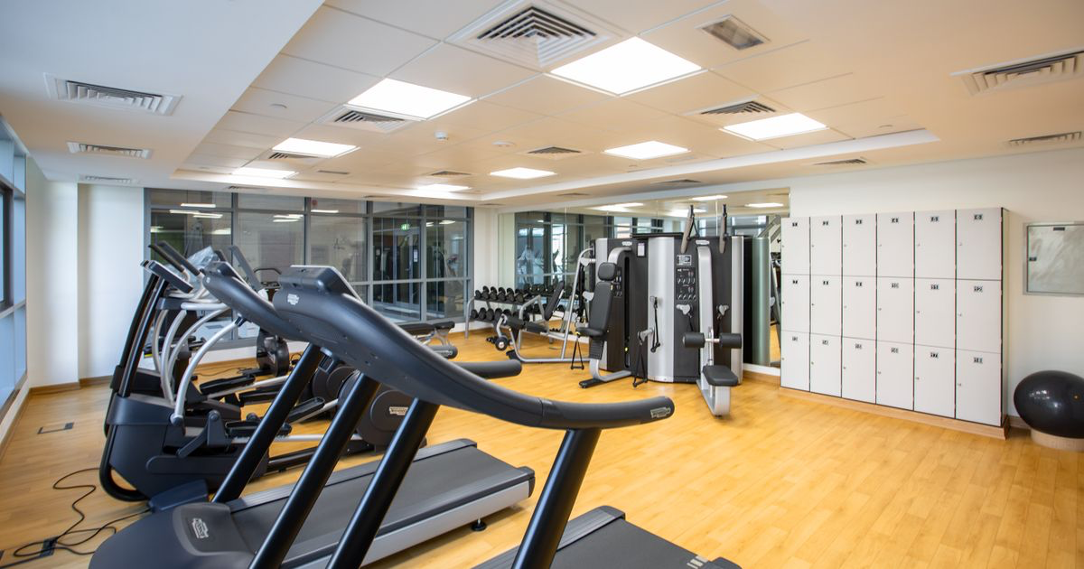 Gym floor with weight machines and free weights, the setting for an upper lower or full body split