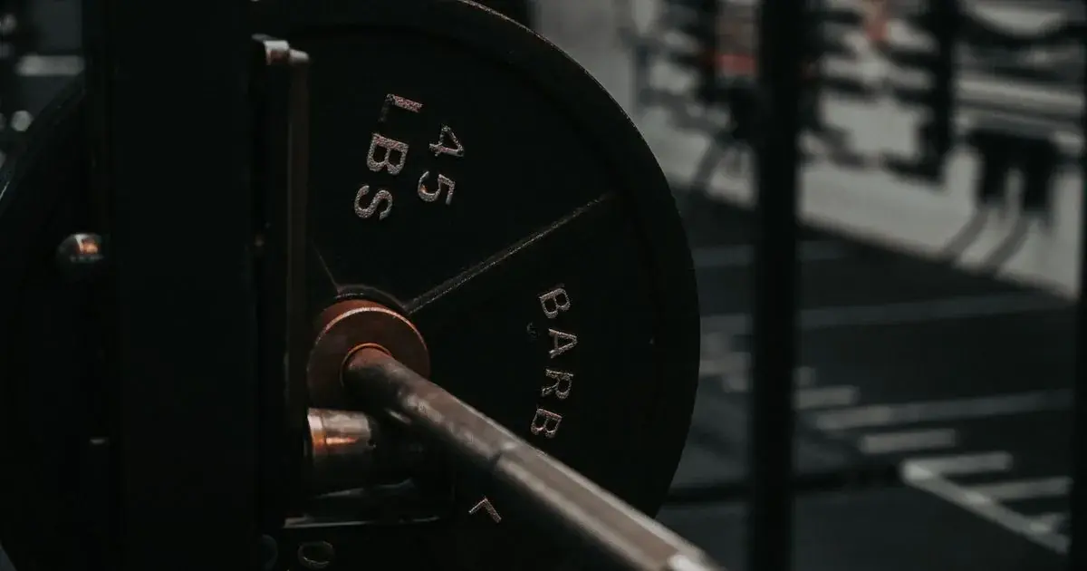 Barbell loaded with a weight plate at the gym, ready to increase weight lifting