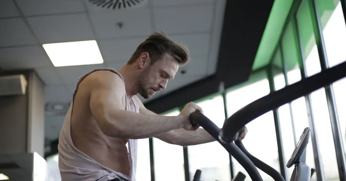Lifter on an exercise bike for the cardio half of a double workout routine