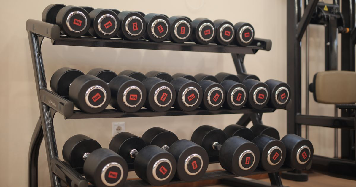 Row of dumbbells on a gym rack showing the weight jumps between pairs