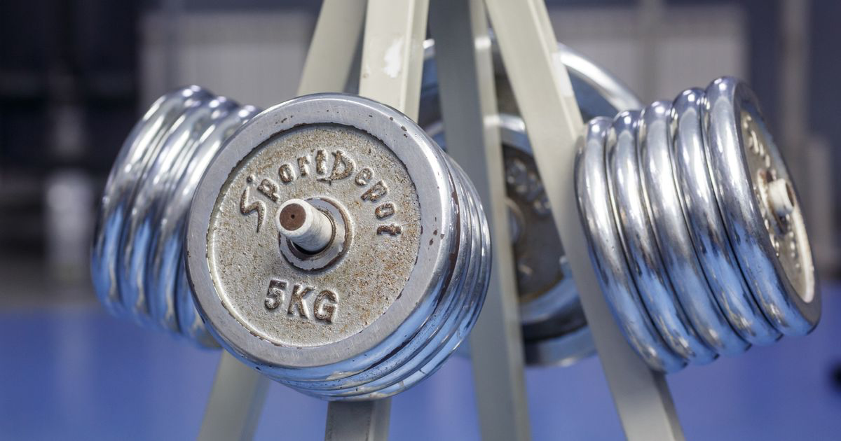 A rack of chrome dumbbells in a quiet gym, waiting for a lifter getting back into the gym after a break