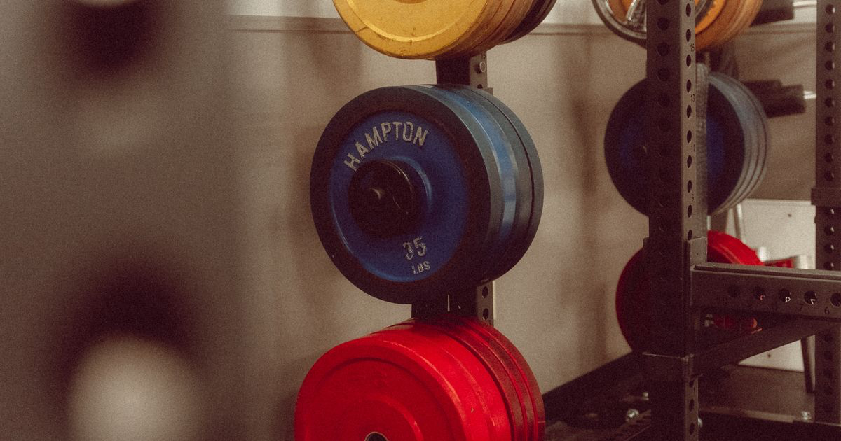 Weight plates racked in a gym, ready to load for a Smith machine workout
