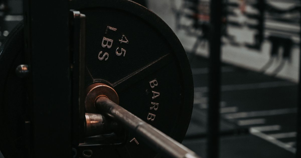 Barbell loaded with a weight plate at the gym, ready to increase weight lifting