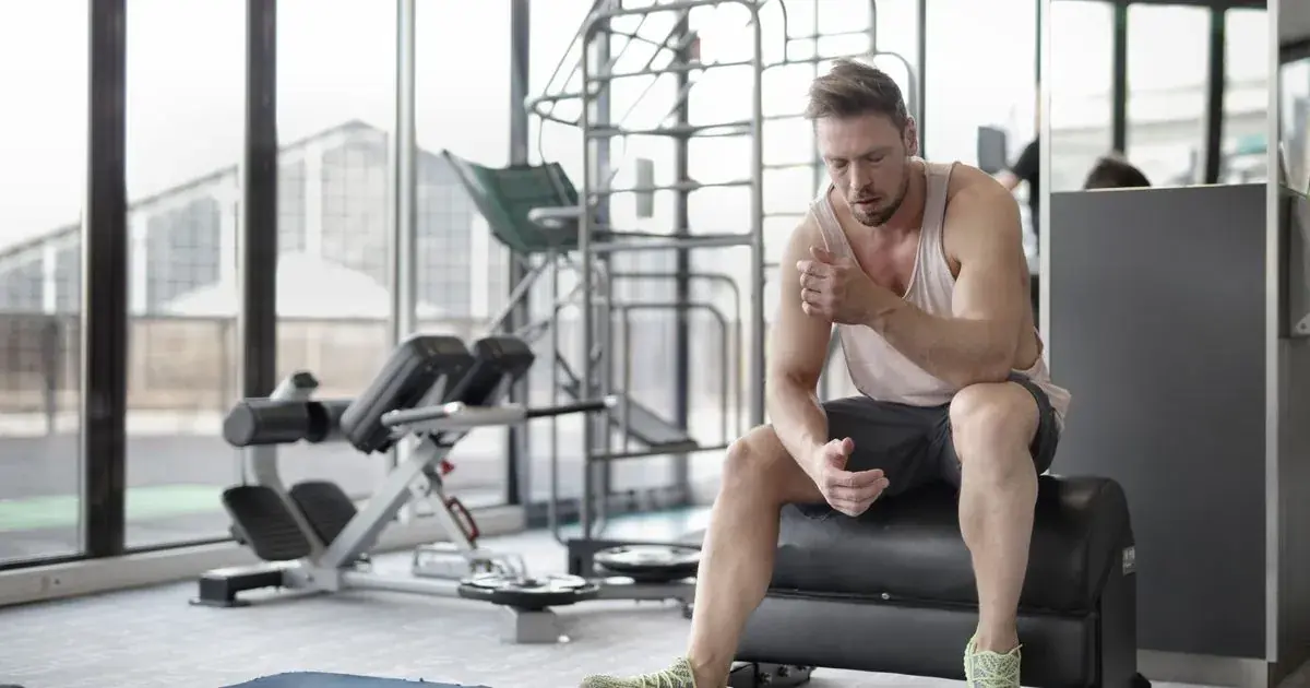 Tired lifter resting on a gym bench, wondering why he is not making progress in the gym